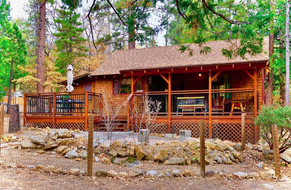A rustic cabin with a wooden deck and a covered porch. - Tuckett Inn | Walk to Town + Fenced Yard (Idyllwild)