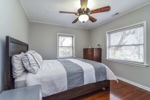 A bedroom with a bed, a nightstand, a dresser, and a ceiling fan. - Pinners Cove: Hot Tub, Fire Pit, Prime Location (Asheville)