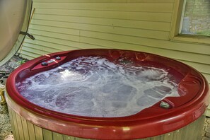 A red hot tub with a control panel, situated outdoors against a house wall. - Pinners Cove: Hot Tub, Fire Pit, Prime Location (Asheville)