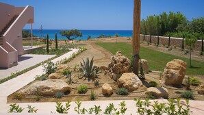 Ein angelegter Garten mit großen Steinen, einer Treppe und Blick auf das Meer.
