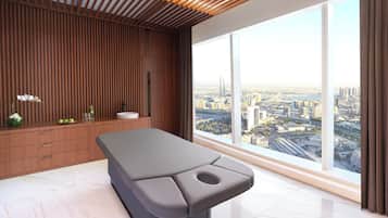 A modern room with a large window, a wooden wall panel, and a massage table.