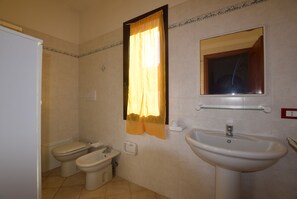 A bathroom with two toilets, a sink, and a mirror. - Le Terrazze sul Mare (Valledoria)