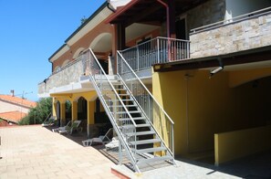A two-story building with a balcony and a staircase leading to the upper floor. - Le Terrazze sul Mare (Valledoria)