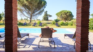 A poolside area with a covered patio, lounge chairs, and a view of the pool. - Domaine du Buc  Les Gites de Prestige (Marssac-sur-Tarn)