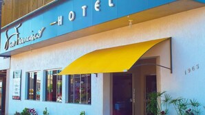 Un hotel con fachada azul, toldo amarillo y el año 1963 exhibido en la pared.