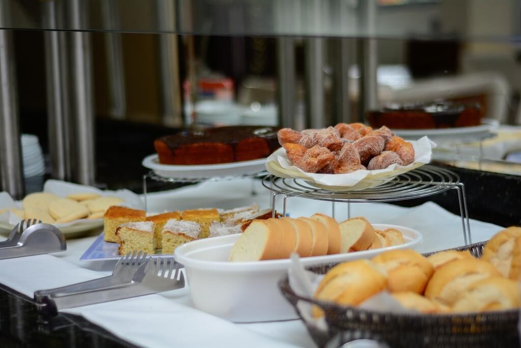 Un bufet amb diferents productes de forneria, incloent pa, pastissos i un pastí.