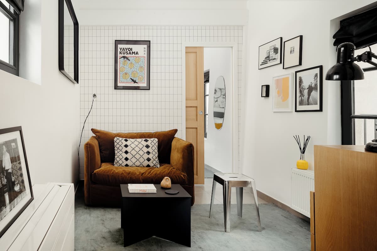 Un salon moderne avec un canapé marron, une table basse noire et une affiche encadrée accrochée au mur.