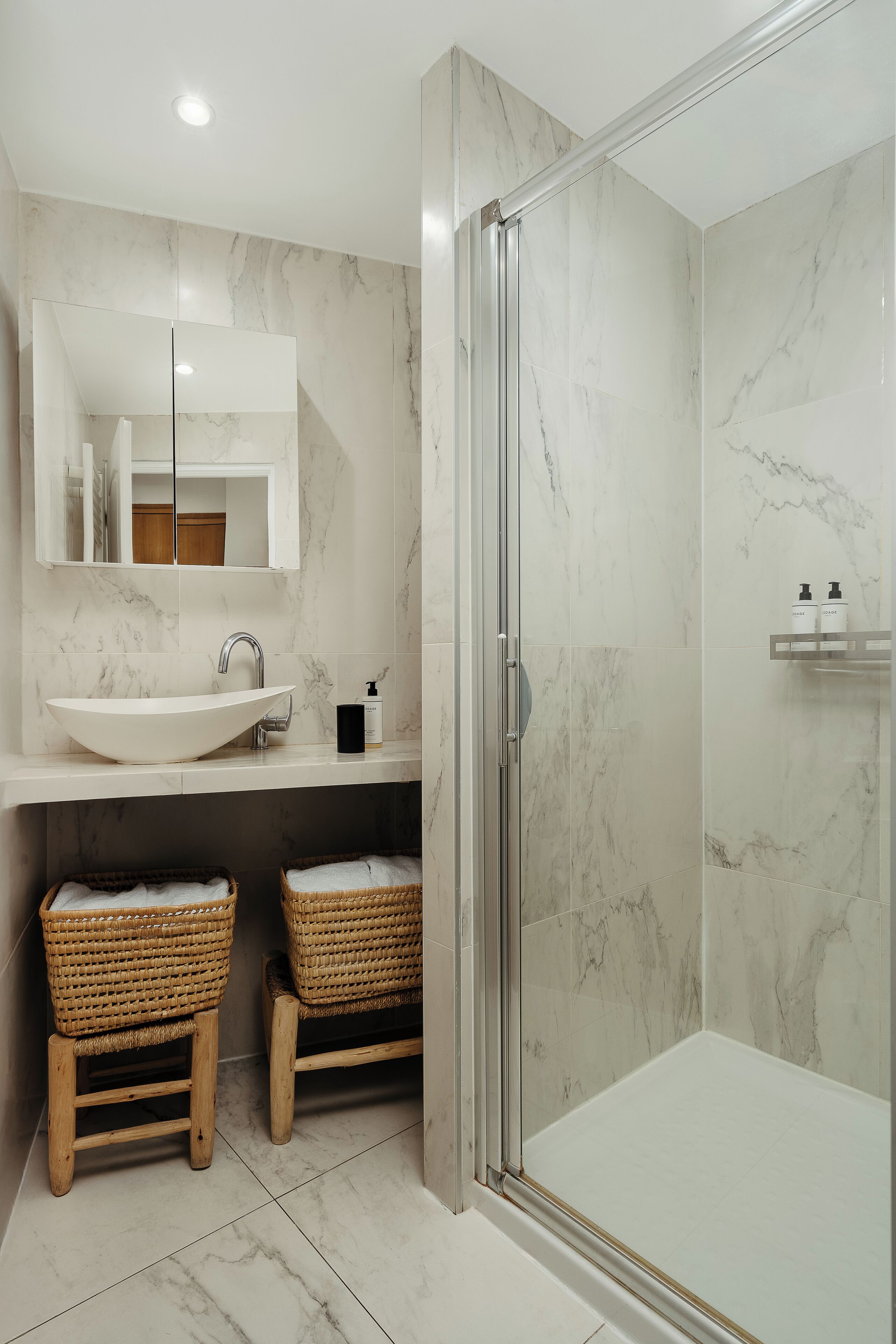 Un bagno moderno con un lavandino ampio, uno specchio e una doccia.