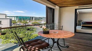 A balcony with a round table, chairs, and a potted plant. - Waterfront Beauty with Parking by Zodiak Stays (Auckland)