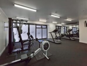 Una palestra con tapis roulant, cyclette e attrezzature per l'allenamento.