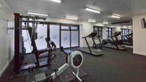 A gym with treadmills, stationary bikes, and exercise equipment. - Superking Bed in Stylish Apartment I Zodiak Stays (Auckland)