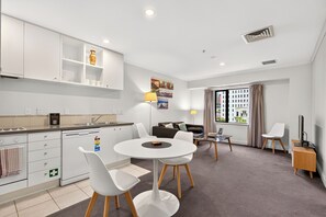 A modern apartment with a kitchen, dining area, and living room. - Superking Bed in Stylish Apartment I Zodiak Stays (Auckland)