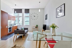 Un apartament modern amb cuina, zona de menjador i saló.