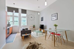 A modern living space with a kitchen, dining area, and seating.