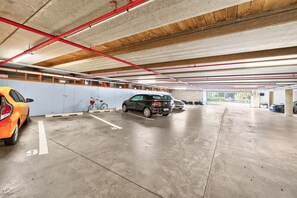 Un parking à plusieurs niveaux, avec des planchers en béton et des poutres en bois au plafond.