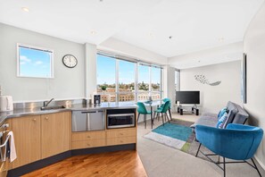 Un appartement moderne comprenant une cuisine, un coin repas et un salon.