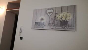 Una pared con un cuadro de una bicicleta y flores.