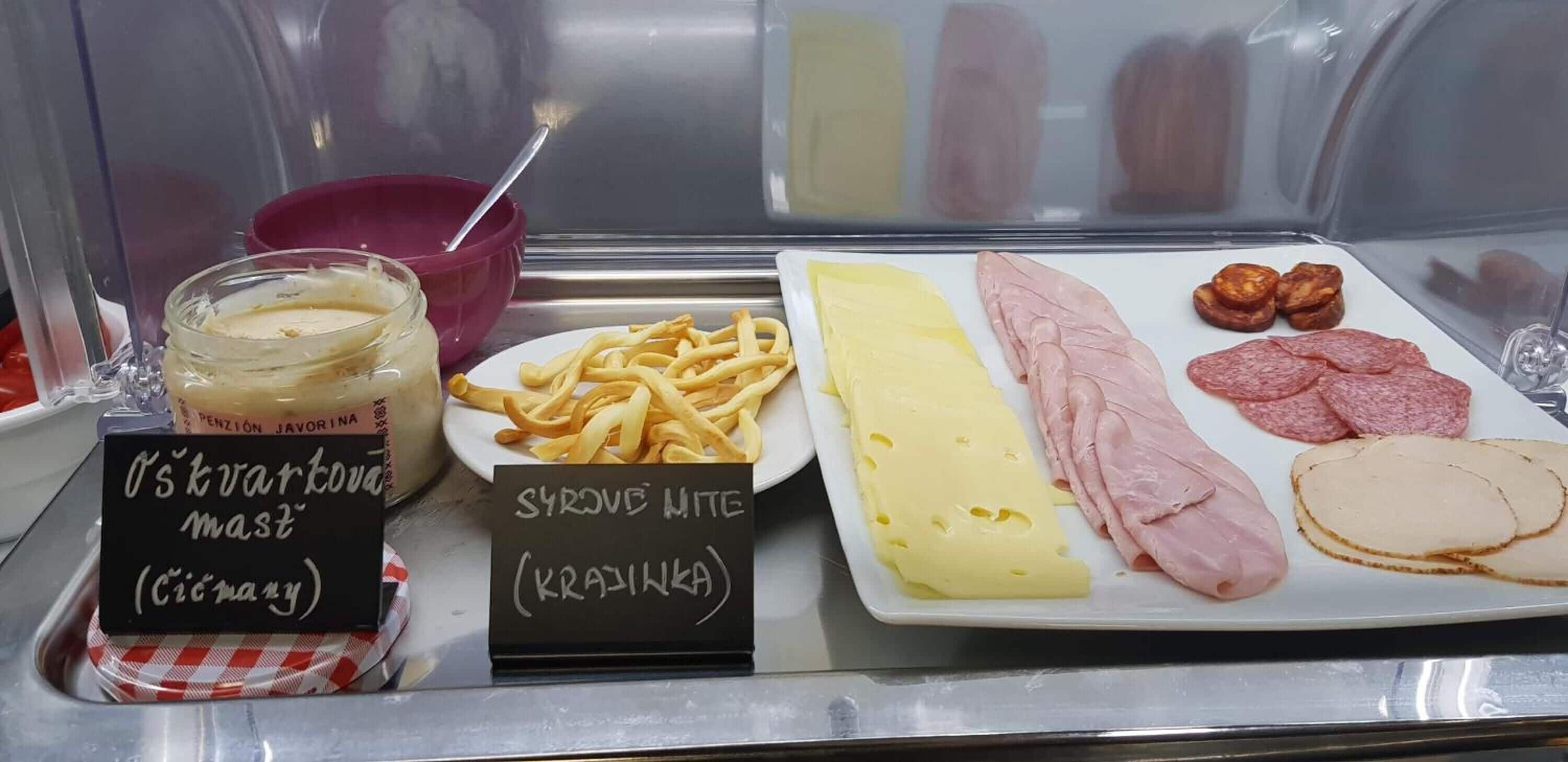 A food display with various items including a jar of mustard, a plate of fries, and different types of cheese and meats.
