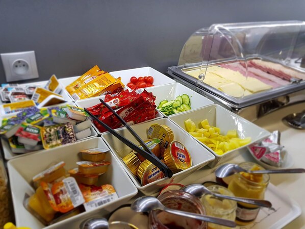 A buffet with various food items including fruits, vegetables, and condiments. - Penzión Galéria (Bojnice)