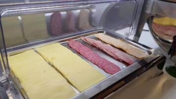 Mostrador de delicatessen con diferentes tipos de embutidos y quesos.