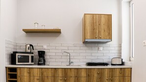 Una cocina moderna con armarios de madera, un microondas, una cafetera y un tostador.