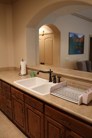 Bathroom features a double sink, mirror, and wooden cabinetry with multiple drawers.