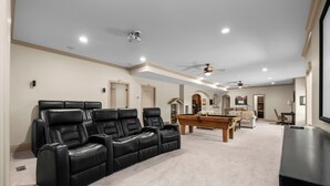 A home entertainment room with a pool table, reclining chairs, and a ceiling fan. - Luxury Basement Full Apartment with Private Entrance (Provo)