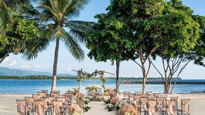 A beach wedding setup with chairs and floral decorations. - Dusit Thani Lubi Plantation Resort (Mabini)