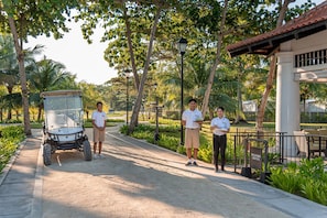 A golf cart, a pathway, and a building with a sign that reads 'WELCOME CENTER'.