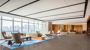 A spacious lobby with a reception desk, seating area, and large windows offering a city view. - Fairfield by Marriott Foshan Nanhai (Foshan)