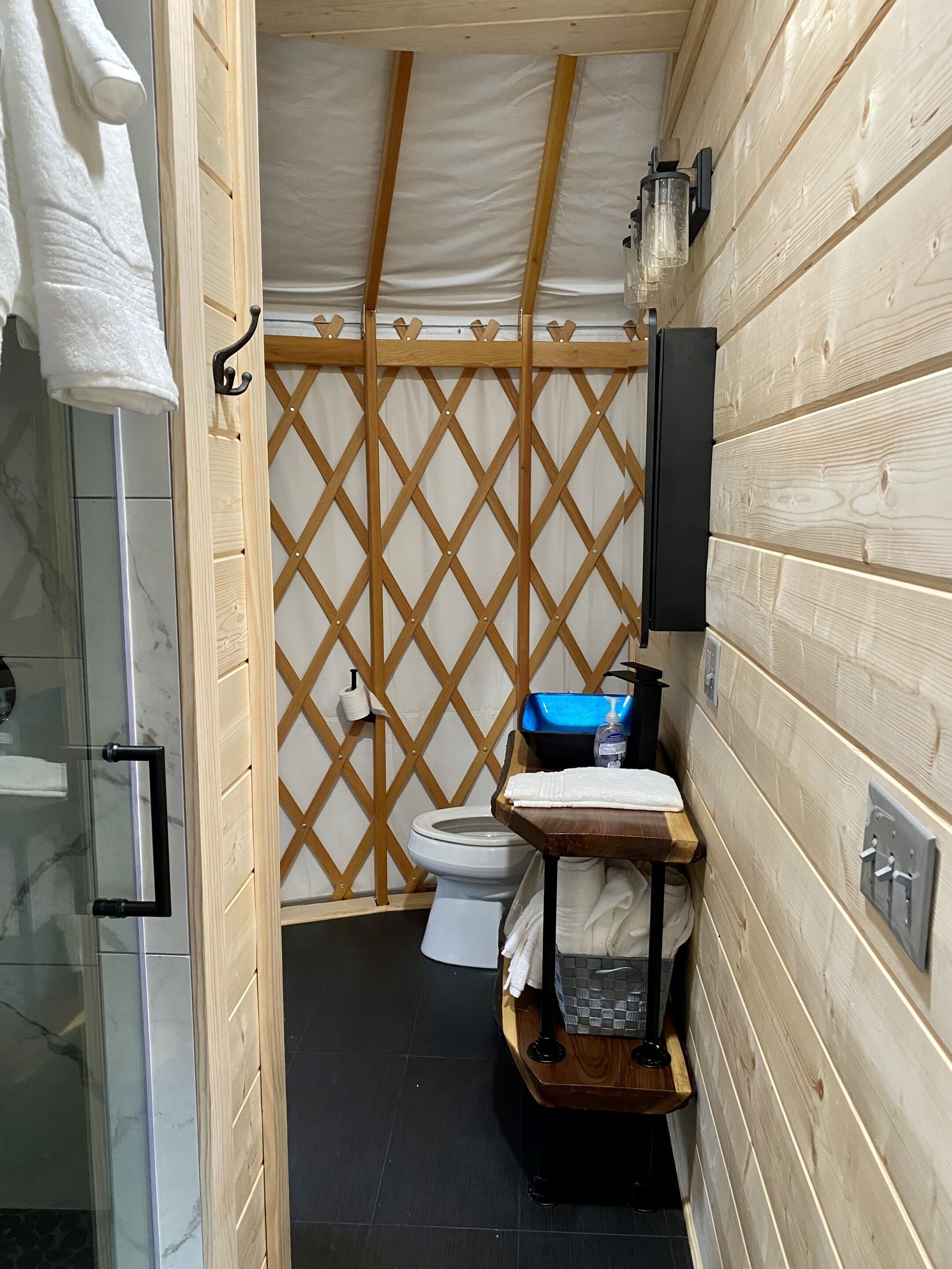A compact bathroom with a toilet, a sink, and a shower area.