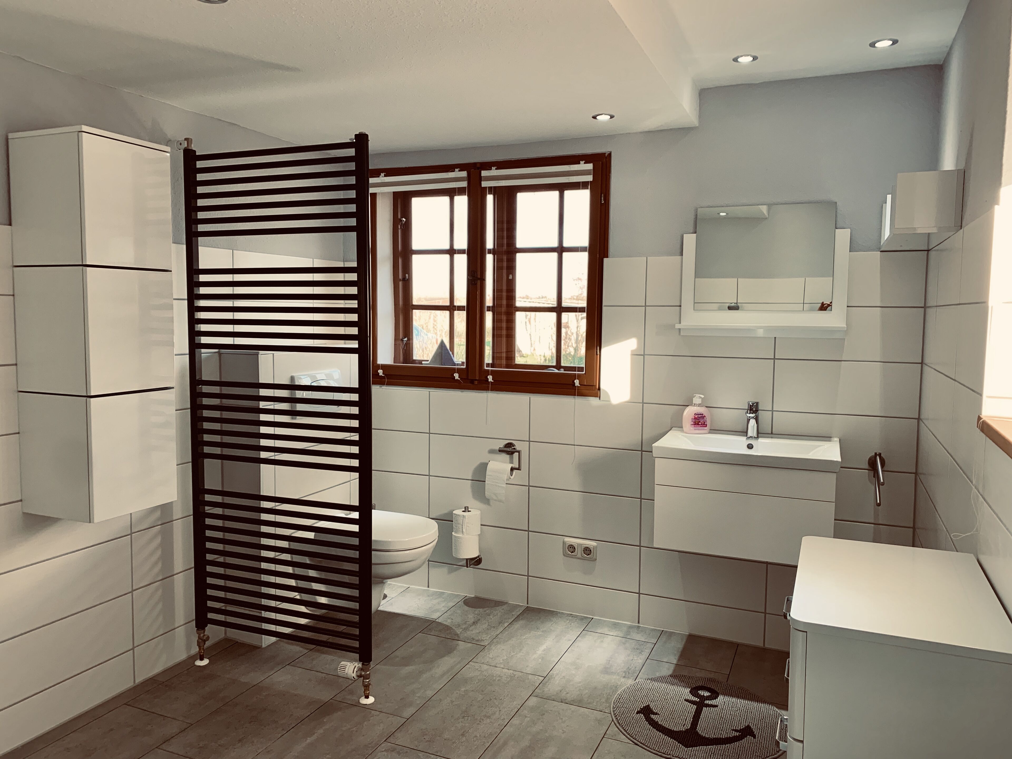A modern bathroom with a toilet, sink, and mirror.