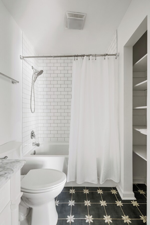 Ein Badezimmer mit Toilette, Badewanne und Duschvorhang.