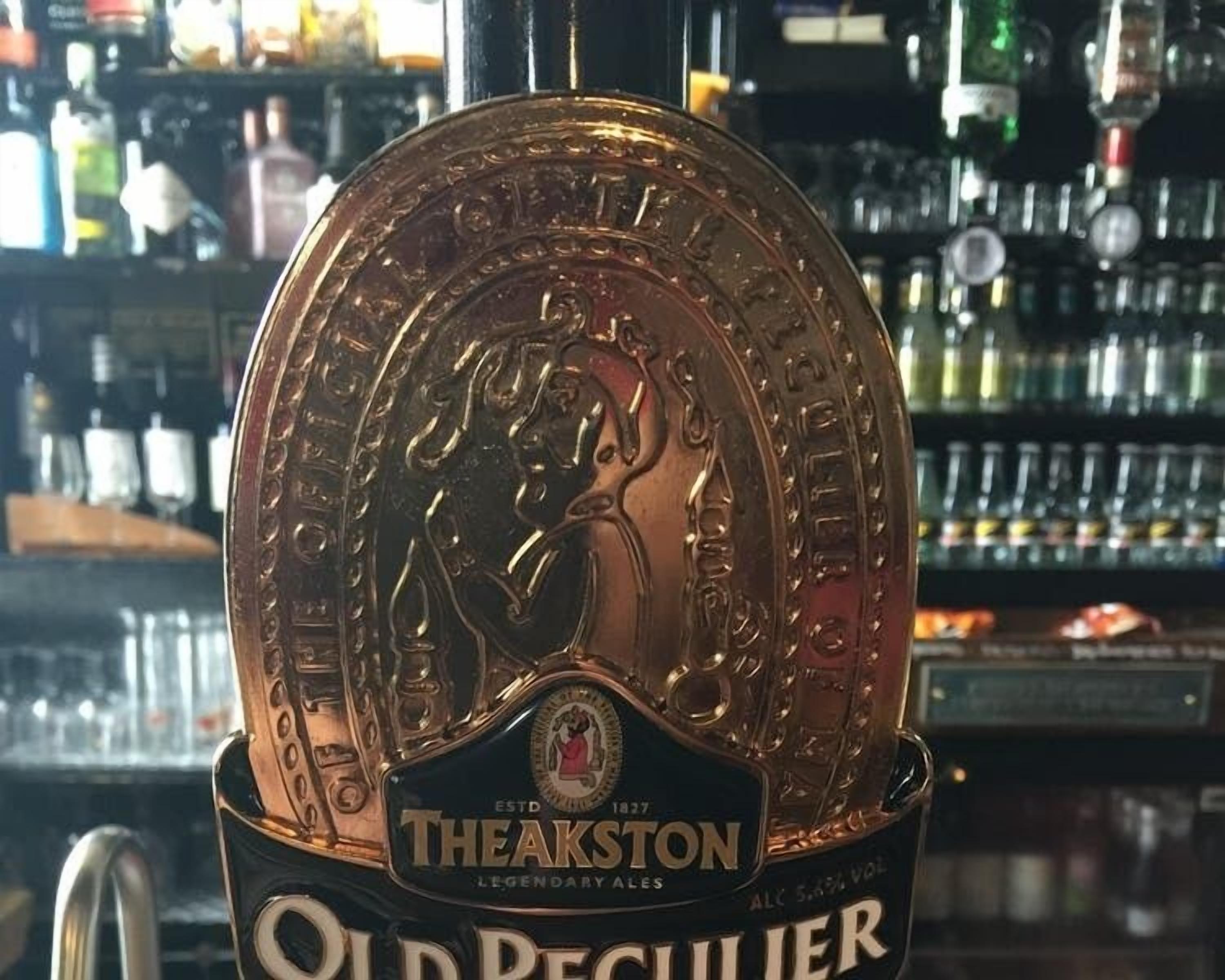 Een bierkraan met een Theakston logo en de tekst 'Old Peculier'.
