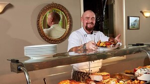 Un buffet proposant des viandes rôties, des légumes et une variété de plats.