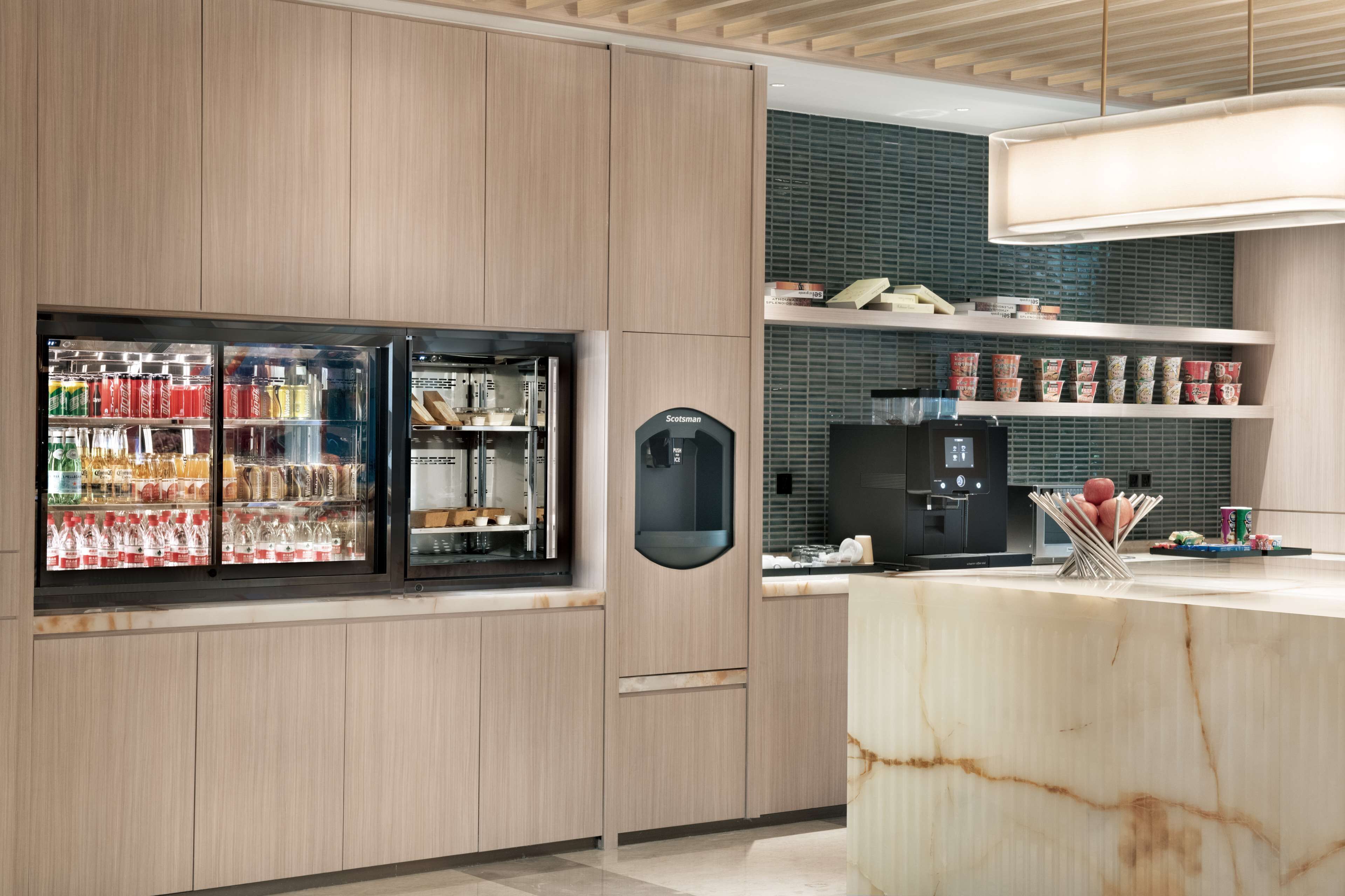 A modern kitchen with wooden cabinets, a marble countertop, and a built-in refrigerator.