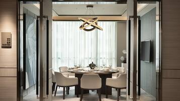 Un espace repas moderne avec une table ronde, six chaises et un lustre.