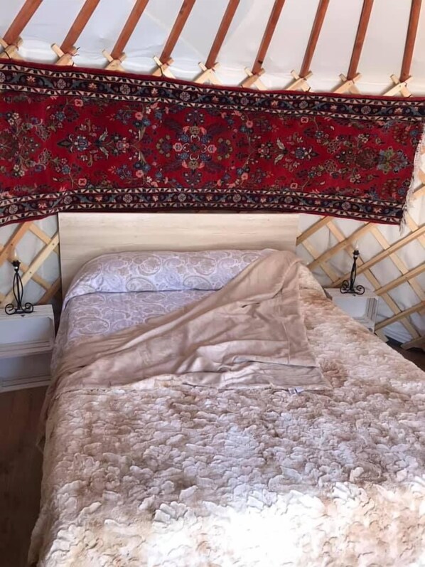 Una cama con un cabecero estampado y un diseño floral rojo en la parte superior.