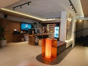 A modern reception area with a flat-screen TV, a reception desk, and a seating area with a sofa. - qema Lima (Lima)