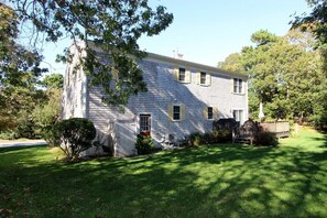 A two-story house with a front porch, a garage, and a well-maintained lawn.