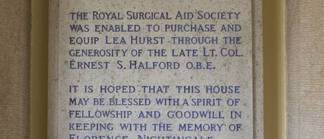 A historical plaque mounted on a wall, detailing the history of a house built in 1820, which was the childhood home of Florence Nightingale.