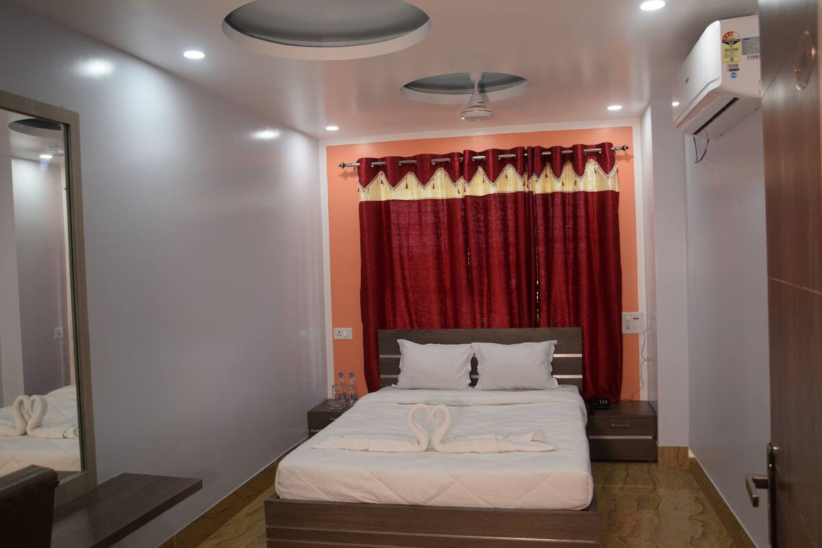 A hotel room with a bed, a nightstand, a mirror, and a ceiling fan.