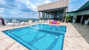 A rooftop pool with a clear view of the city skyline, surrounded by modern lounge chairs and potted plants. - [NEW & NICE VIEW] Premium Suite 2-4Pax Near KLCITY (Taman Sri Hartamas)