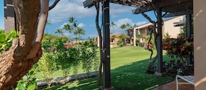 Enjoy a peaceful retreat amidst lush tropical plants and a serene pergola-shaded area.