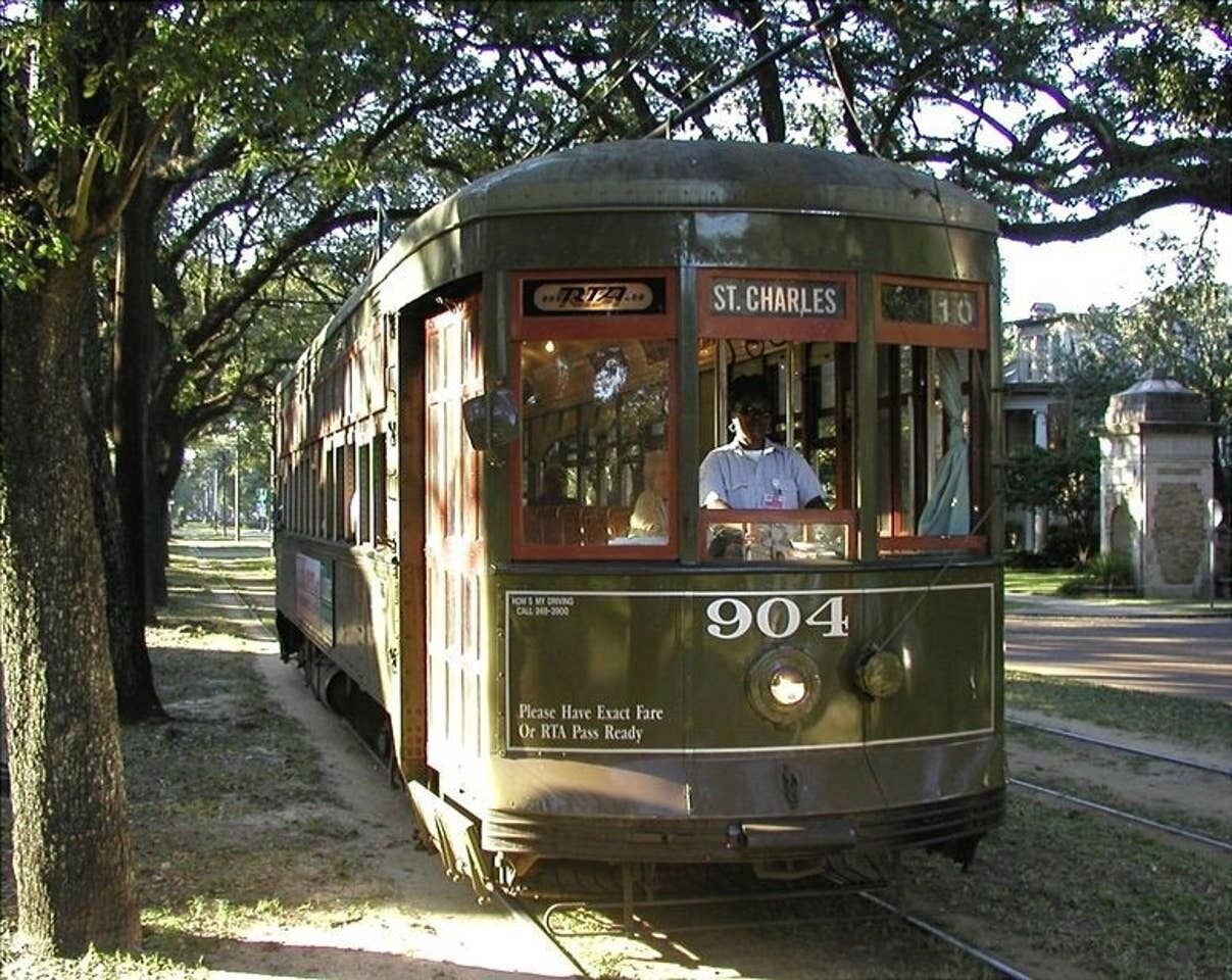 A vintage trolley with a sign reading "ST. CHARLES" and route number "904" parked on tracks.