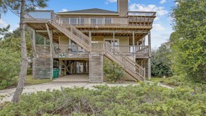 A two-story wooden house with a balcony, a staircase, and a chimney. - 1067 - Easy Street - Short Walk to Beach | Pool & Hot Tub (Corolla)