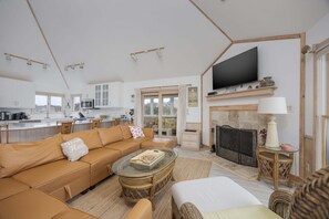 A spacious living area with a sofa, coffee table, and a television.