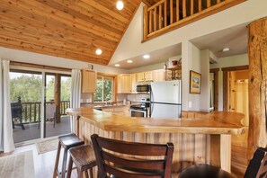 A spacious kitchen with wooden cabinets, a large island, and a view of the outdoors.