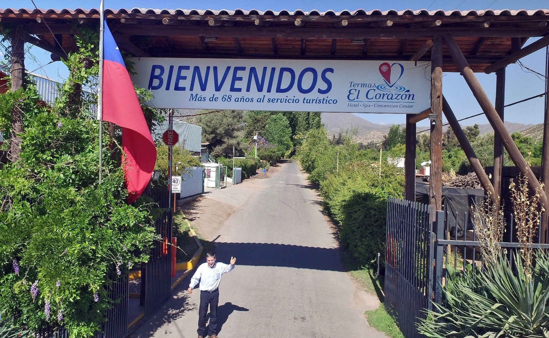 A sign welcoming visitors to a hotel with a banner stating "BIENVENIDOS Más de 68 años al servicio turístico" and "Termas El Corazón Hotel Spa Convention Center".