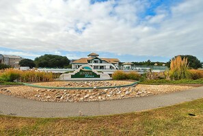 A sign for Monterra Shores with a view of a large building and a landscaped area with rocks and plants.